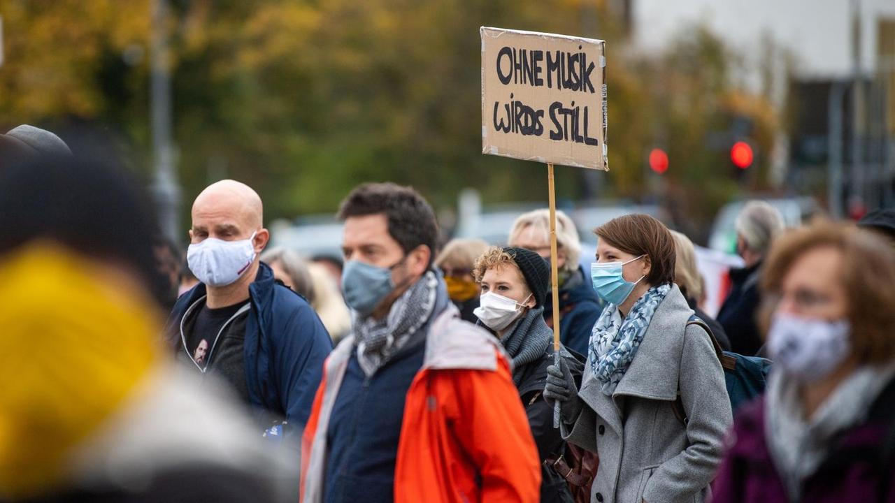 Eine Frau hält bei einer Demonstration am Königsplatz in München ein Schild mit der Aufschrift «Ohne Musik wirds still.» Unter dem Motto «Aufstehen für die Kultur» erinnern Künstler an die schwierigen Lebenssituationen, die aus der Coronakrise für viele Kulturschaffende entstanden sind. Eine Frau hält bei einer Demonstration am Königsplatz in München ein Schild mit der Aufschrift «Ohne Musik wirds still.» Unter dem Motto «Aufstehen für die Kultur» erinnern Künstler an die schwierigen Lebenssituationen, die aus der Coronakrise für viele Kulturschaffende entstanden sind.