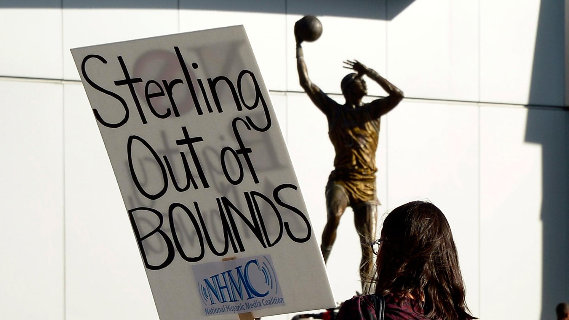Ein Fan hält bei den Protesten zur "Los Angeles Clippers Conference" ein Schild mit der Aufschrift "Sterling out of Bounds" in den Händen.