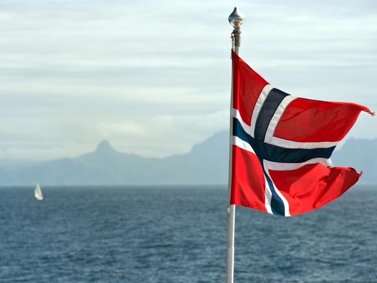 Die Fahne von Norwegen weht im Wind auf einer Fähre unweit der nordnorwegischen Stadt Bodø am Europäischen Nordmeer, aufgenommen am 21.07.2011.
