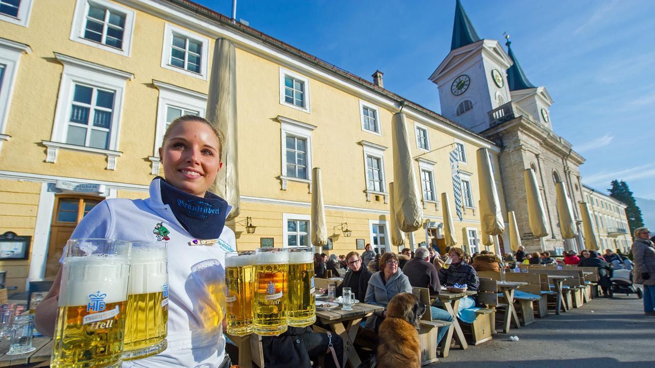 Eine Kellnerin trägt am 12.01.2014 vor dem Herzöglichen Bräustüberl in Tegernsee (Bayern) mehrere Helle zu einem Tisch. Eine Kellnerin trägt am 12.01.2014 vor dem Herzöglichen Bräustüberl in Tegernsee (Bayern) mehrere Helle zu einem Tisch.