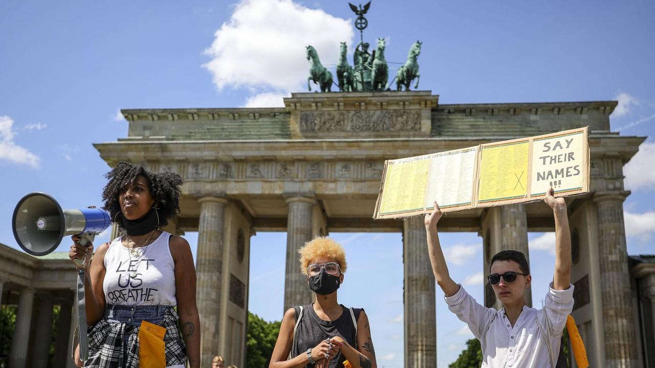 Aktivisten vor dem Brandenburger Tor halten ein Schild mit der Aufschrift "Say Their Names" in die Höhe. Aktivisten vor dem Brandenburger Tor halten ein Schild mit der Aufschrift "Say Their Names" in die Höhe.