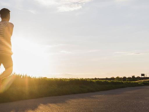 Ein Jogger läuft im Sonnenuntergang