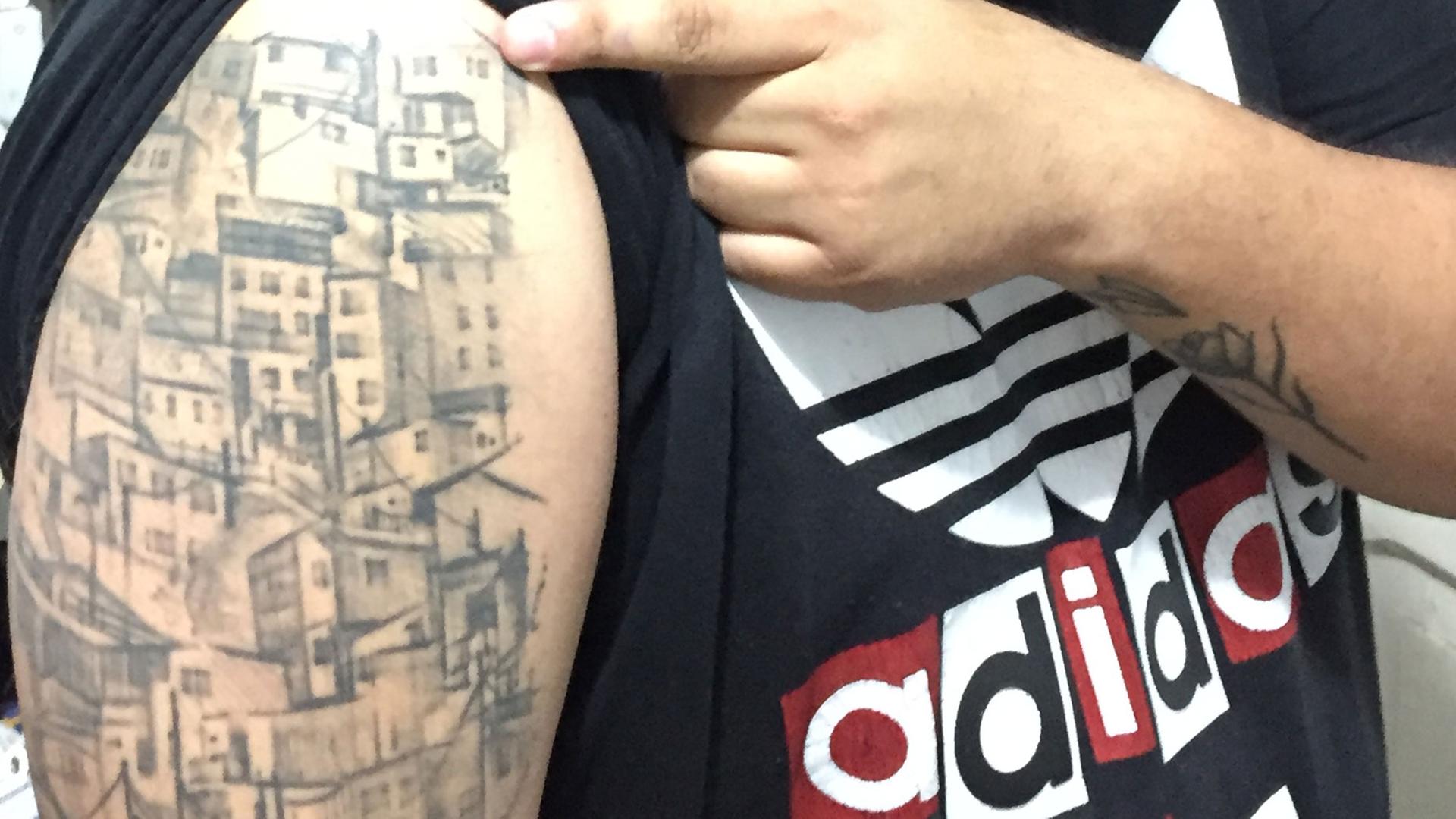 Der Rapper Jeihhco hat sich ein Bild seines Viertels auf dem Oberarm tätowieren lassen Der Rapper Jeihhco hat sich ein Bild seines Viertels auf dem Oberarm tätowieren lassen