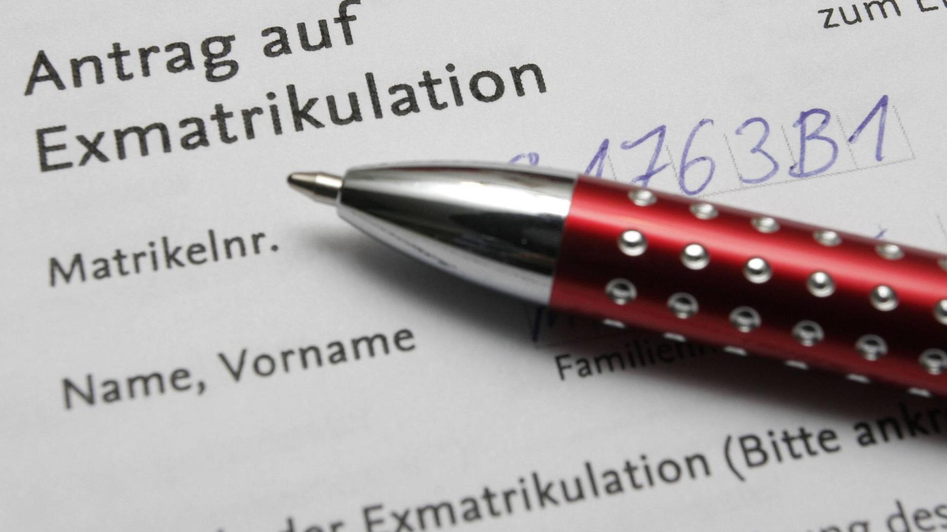 Ein weißes Dokument mit aufgedruckter Schrift. Zu lesen ist: "Antrag auf Exmatrikulation". Auf dem Blatt Papier liegt ein rot-silberner Kugelschreiber. file_source: imago stock&people Ein weißes Dokument mit aufgedruckter Schrift. Zu lesen ist: "Antrag auf Exmatrikulation". Auf dem Blatt Papier liegt ein rot-silberner Kugelschreiber. file_source: imago stock&people