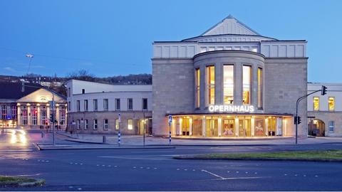 Das Opernhaus Wuppertal im Abendlicht und beleuchteter Beschriftung.
