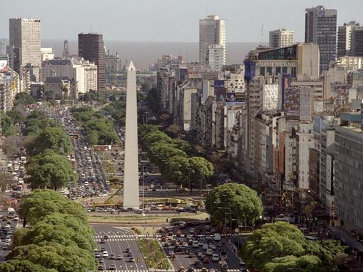 Blick nach Norden über die Avenida 9 de Julio, die Hauptverkehrsachse von Buenos Aires (Aufnahme vom November 2005). Sie misst mit ihren zehn Fahrspuren 125 Meter in der Breite. An der Kreuzung Avenida Corrientes steht als Wahrzeichen der Stadt ein 67,5 Meter hoher Obelisk, der am 25.05.1938 zum 400. Gründungstag aufgestellt wurde.