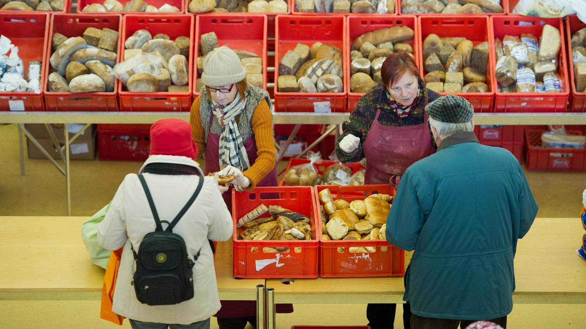 Brot verteilen ehrenamtliche Helferinnen in Wiesbaden (Hessen) am 13.12.2012 in der Tafel der Stephanusgemeinde an Bedürftige. Zur Klientel der ausschliesslich spendenfinanzierten Tafel gehören unter anderem Rentner, Arbeitslose, Alleinerziehende und Geringverdiener. Foto: Boris Roessler dpa (Zu dpa-lhe Blickpunkt "Wenn es nicht reicht: Tafeln in Hessen haben grossen Zulauf" vom 16.12.2012) | Verwendung weltweit Brot verteilen ehrenamtliche Helferinnen in Wiesbaden (Hessen) am 13.12.2012 in der Tafel der Stephanusgemeinde an Bedürftige. Zur Klientel der ausschliesslich spendenfinanzierten Tafel gehören unter anderem Rentner, Arbeitslose, Alleinerziehende und Geringverdiener. Foto: Boris Roessler dpa (Zu dpa-lhe Blickpunkt "Wenn es nicht reicht: Tafeln in Hessen haben grossen Zulauf" vom 16.12.2012) | Verwendung weltweit