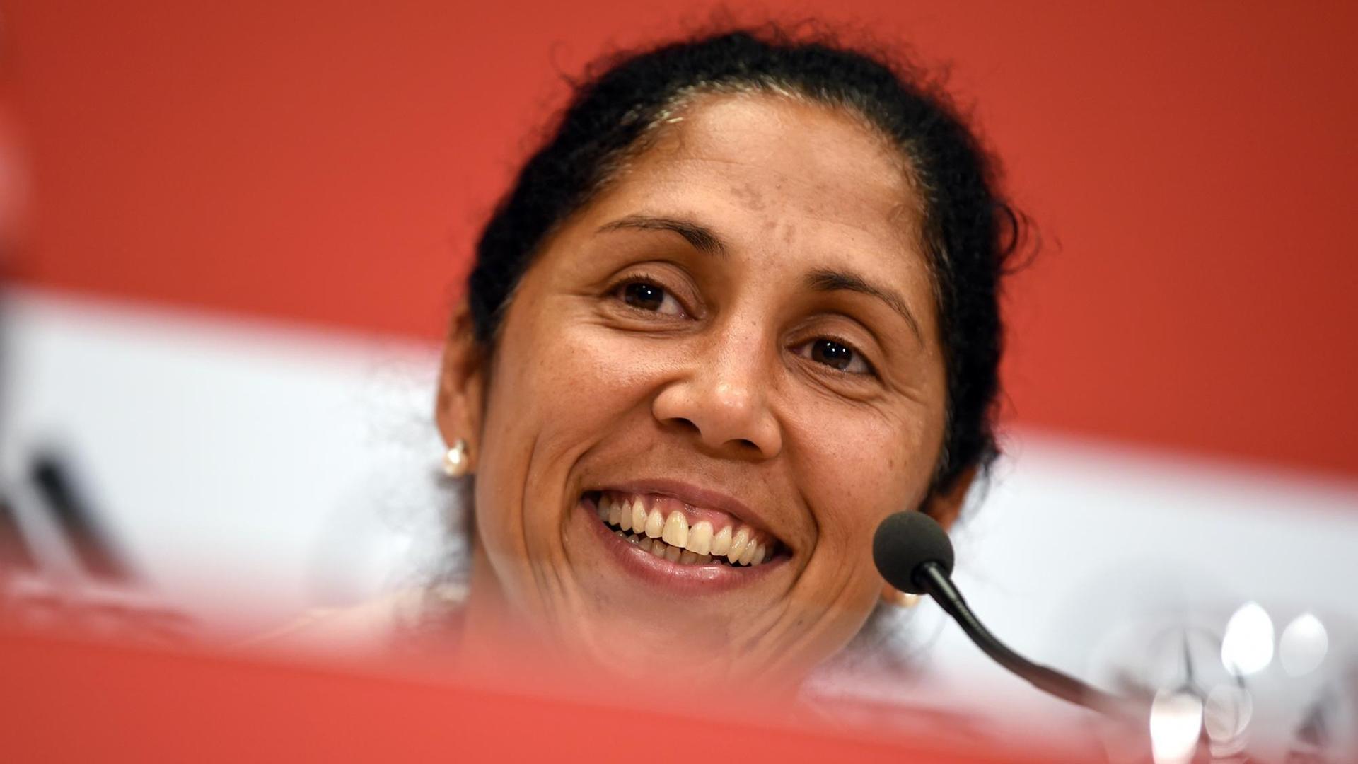 Steffi Jones lacht bei einer Pressekonferenz in die Kameras Steffi Jones lacht bei einer Pressekonferenz in die Kameras