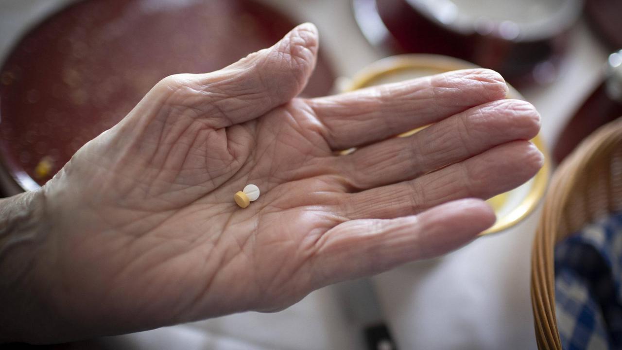 Alte Hand mit zwei Tabletten Alte Hand mit zwei Tabletten
