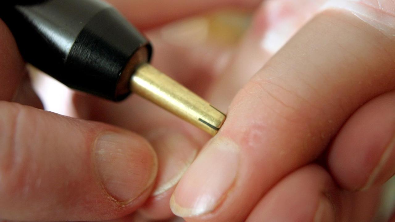 Ein metallisches Messgerät wird an einen Finger gedrückt. Ein metallisches Messgerät wird an einen Finger gedrückt.