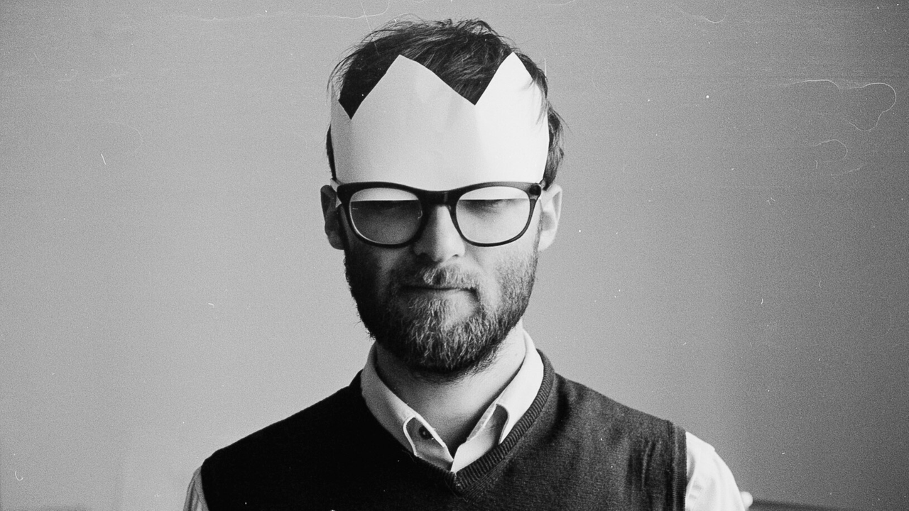 Vorbereitungen zum Generationswechsel nach Shakespeares König Lear. Zu sehen: Ein schwarz-weiß-Foto mit einem Mann, der eine Pappkrone und eine große Brille trägt. Vorbereitungen zum Generationswechsel nach Shakespeares König Lear. Zu sehen: Ein schwarz-weiß-Foto mit einem Mann, der eine Pappkrone und eine große Brille trägt.