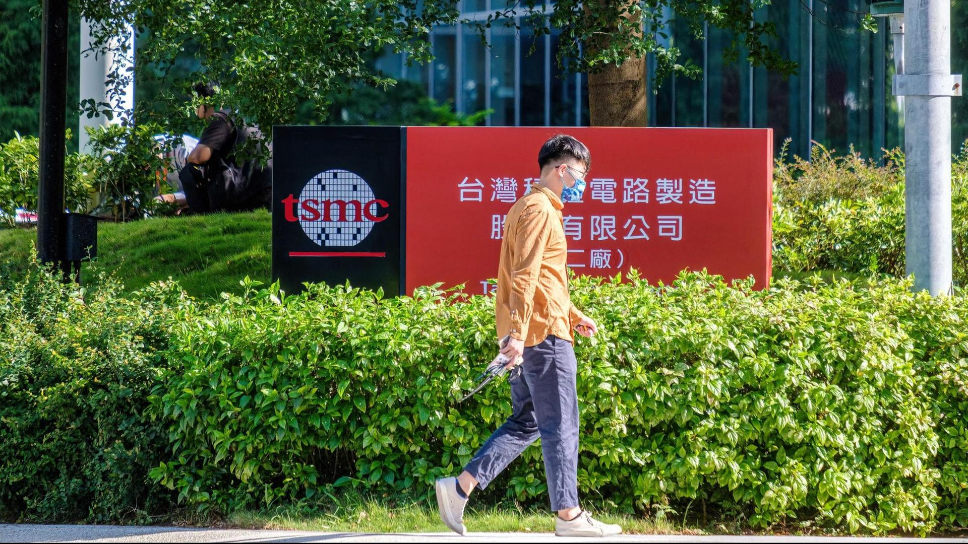 Eine Person mit Coronamaske läuft vor einem Firmengebäude von TSMC (Taiwan Semiconductor Manufacturing Company) in Hsinchu, Taiwan, entlang. Eine Person mit Coronamaske läuft vor einem Firmengebäude von TSMC (Taiwan Semiconductor Manufacturing Company) in Hsinchu, Taiwan, entlang.