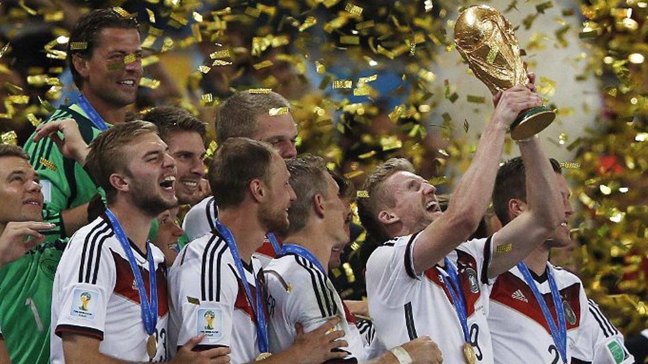 Die Nationalspieler stehen in einem Regen aus goldenen Papierschnipseln und halten den WM-Pokal in die Luft. Die Nationalspieler stehen in einem Regen aus goldenen Papierschnipseln und halten den WM-Pokal in die Luft.