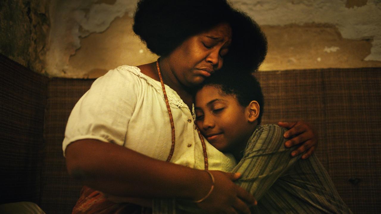Filmstill aus Todos os mortos: Eine Frau hält ein Kind in ihren Armen. Filmstill aus Todos os mortos: Eine Frau hält ein Kind in ihren Armen.