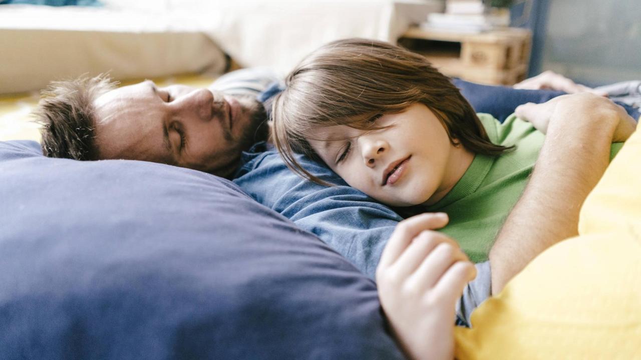 Vater und Sohn schlafend, in liebevoller Umarmung. Vater und Sohn schlafend, in liebevoller Umarmung.