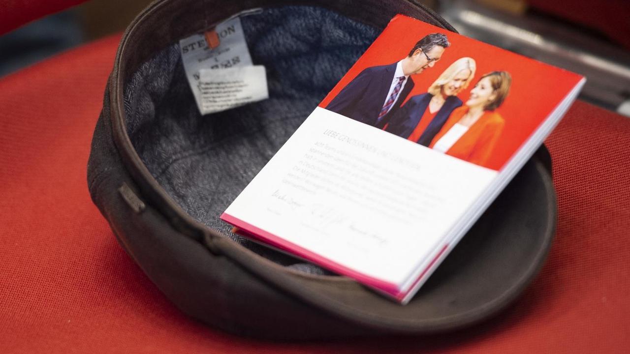 Ein SPD-Prospekt mit den Kandidaten für den Vorsitz liegt in einer Schiebermütze Ein SPD-Prospekt mit den Kandidaten für den Vorsitz liegt in einer Schiebermütze