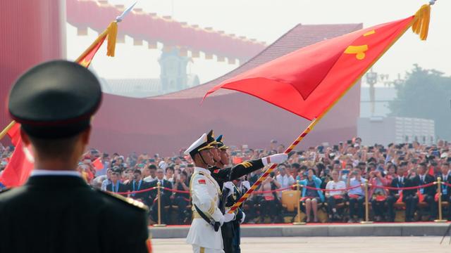 Soldaten, die eine chinesische Flagge tragen bei einer Parade