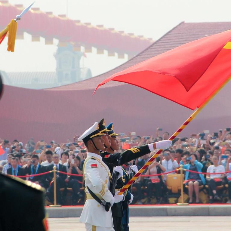 Soldaten, die eine chinesische Flagge tragen bei einer Parade