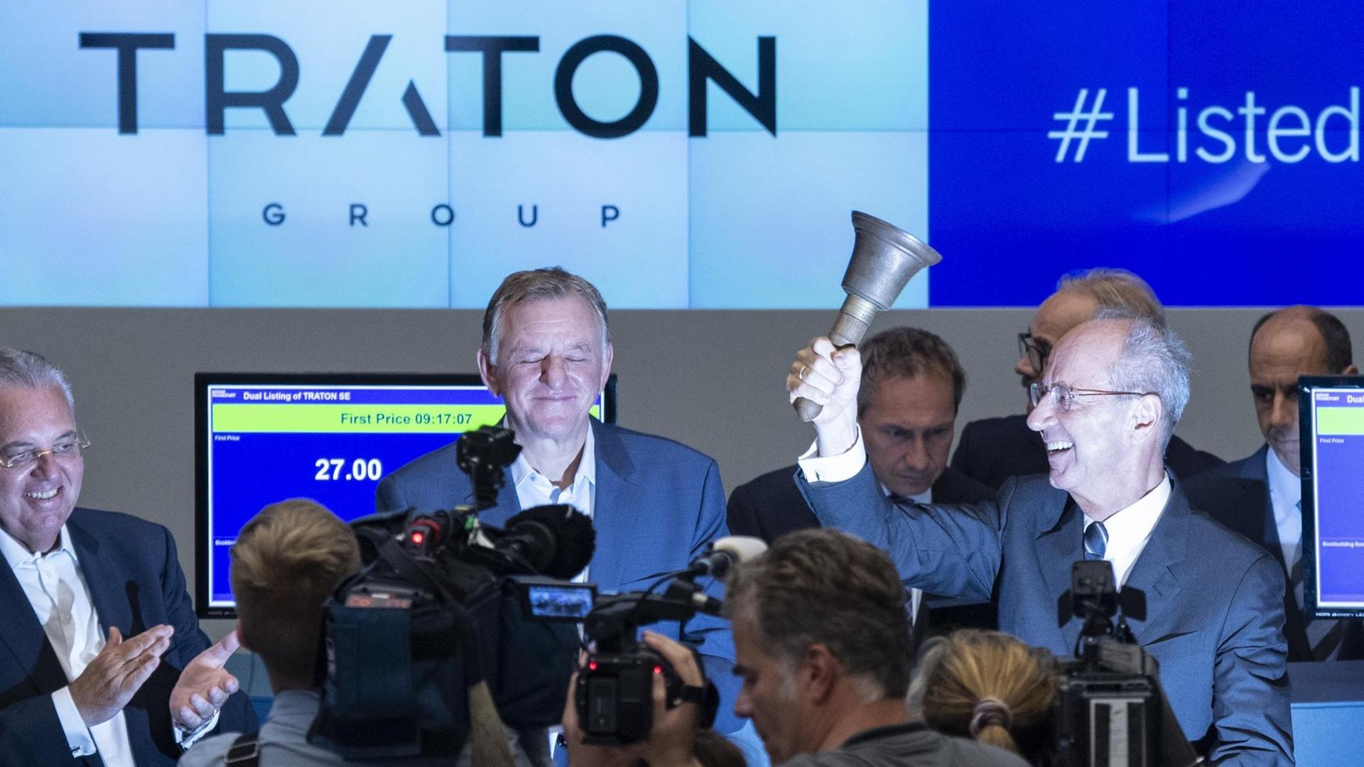 Andreas Renschler (M), Vorstandsvorsitzender der Traton SE lächelt beim Börsengang des Unternehmens, während Hans Dieter Pötsch, Vorsitzender des Aufsichtsrats die obligatorische Glocke läutet.