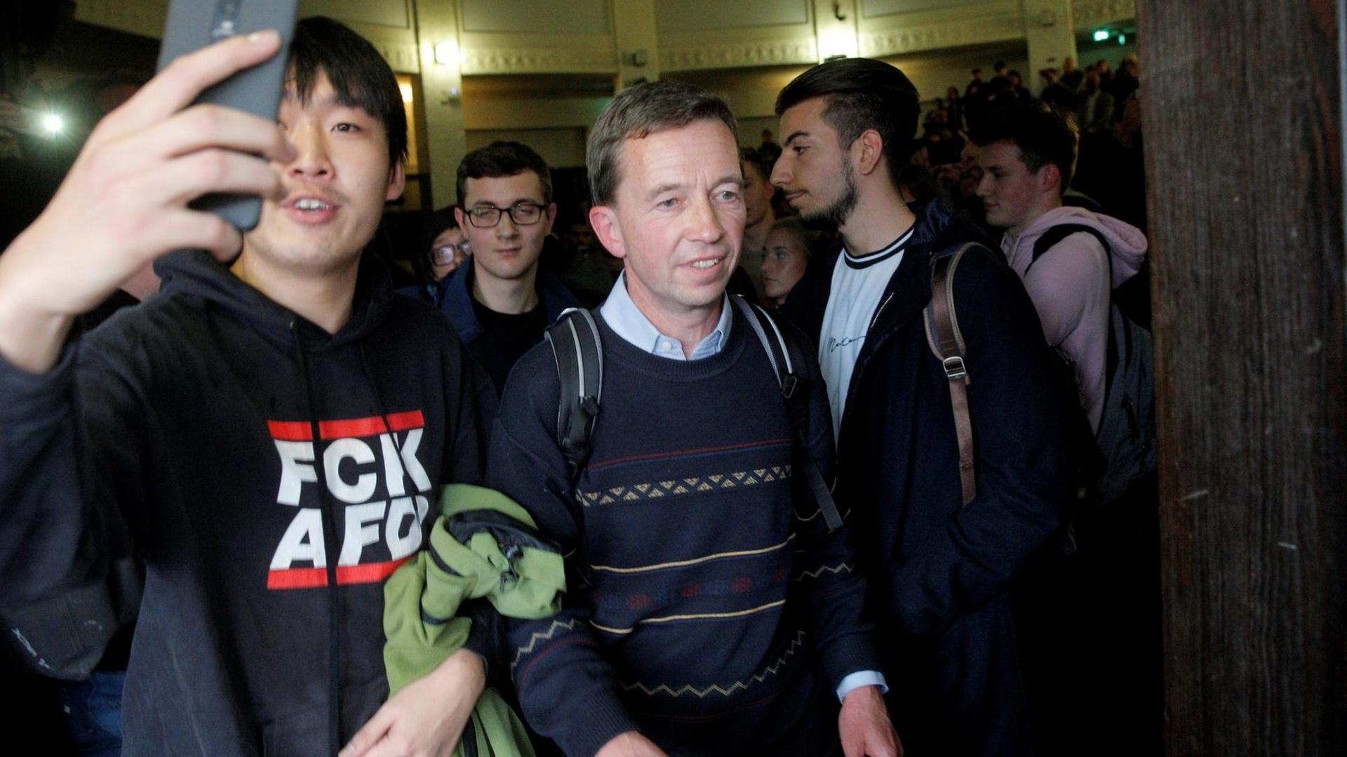 Bernd Lucke drängt sich nach seiner verhinderten Vorlesung aus dem Saal. Neben ihm ein Demonstrant in einem Pullover mit der Aufschrift "FCK AFD". Bernd Lucke drängt sich nach seiner verhinderten Vorlesung aus dem Saal. Neben ihm ein Demonstrant in einem Pullover mit der Aufschrift "FCK AFD".