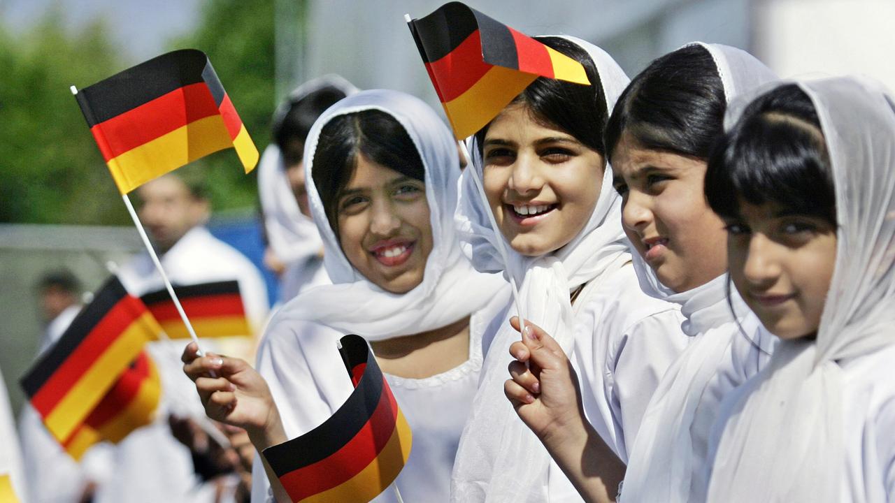 Muslimische Mädchen schwenken auf der Jahresversammlung der moslemischen Reformgemeinde Ahmadiyya auf dem Maimarktgelände in Mannheim deutsche Fahnen. Muslimische Mädchen schwenken auf der Jahresversammlung der moslemischen Reformgemeinde Ahmadiyya auf dem Maimarktgelände in Mannheim deutsche Fahnen.