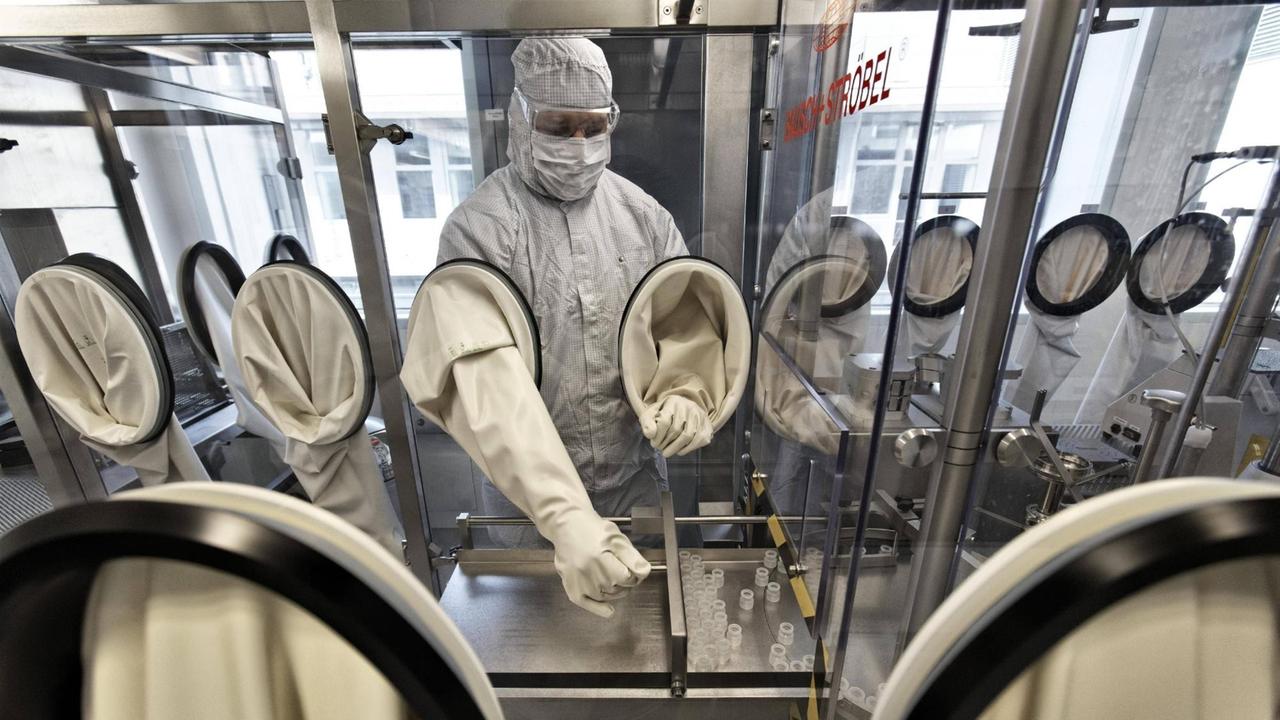 Ein Laborant hantiert mit Proben in einer Sicherheitswerkbank bei der CureVac GmbH im Technologiepark Tübingen-Reutlingen