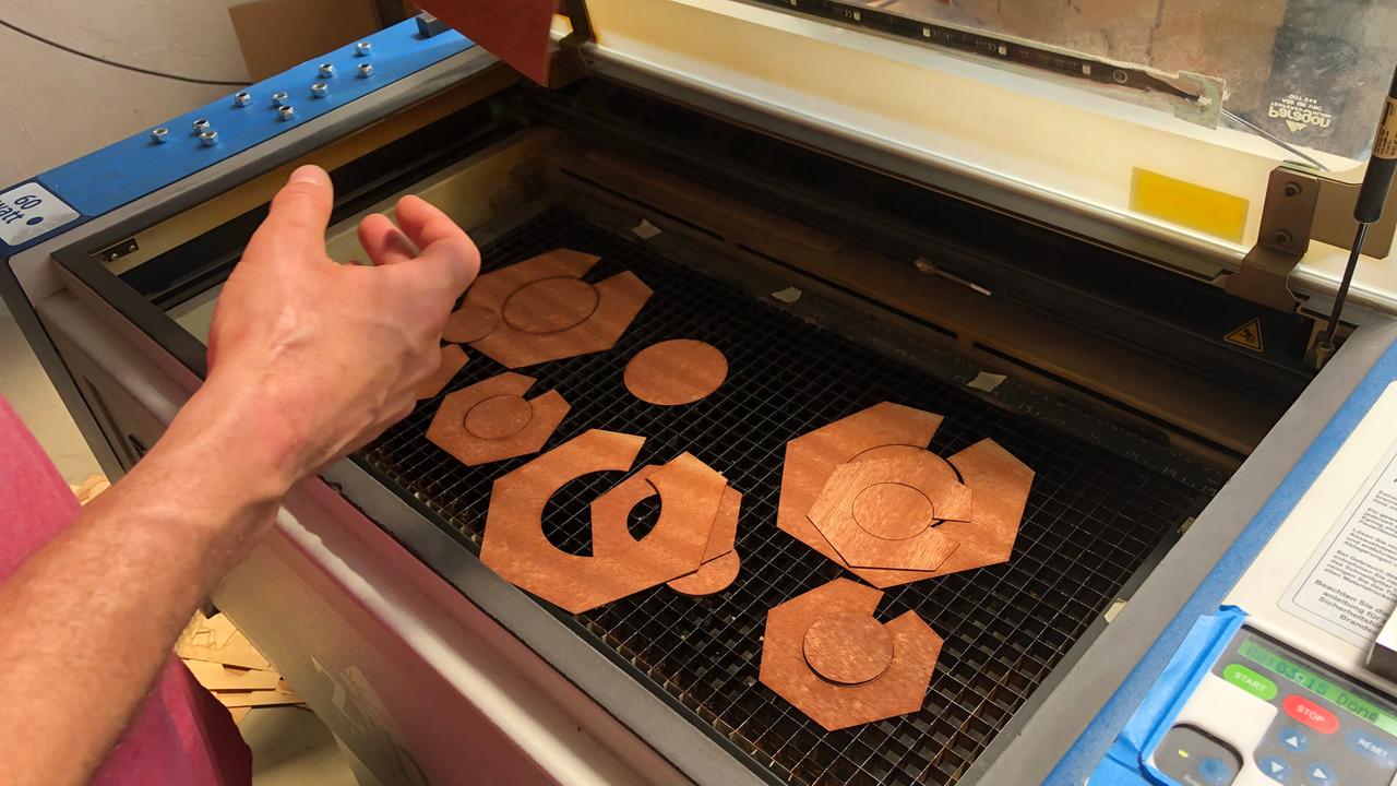 Blick auf einen Laser Laser-Cutter in den Räumen des FabLab St. Pauli in Hamburg. Darauf mehrere bereits durch den Laser zugeschnittene Teile. Blick auf einen Laser Laser-Cutter in den Räumen des FabLab St. Pauli in Hamburg. Darauf mehrere bereits durch den Laser zugeschnittene Teile.