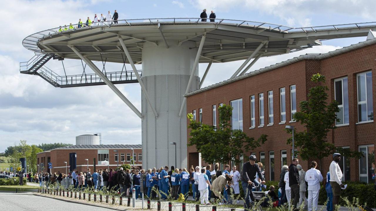 Angestellte des Aarhuser Universitätsklinikums formen eine Menschenkette um das Gebäude um gegen Kürzungen ihrer finanziellen Mittel zu protestieren. Angestellte des Aarhuser Universitätsklinikums formen eine Menschenkette um das Gebäude um gegen Kürzungen ihrer finanziellen Mittel zu protestieren.