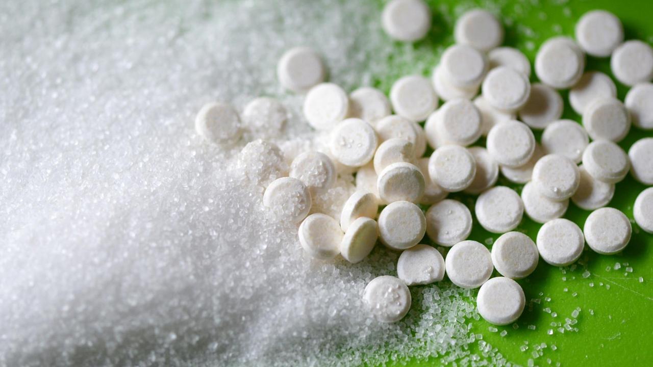 Stevia in Tablettenform neben Haushaltszucker. Stevia in Tablettenform neben Haushaltszucker.