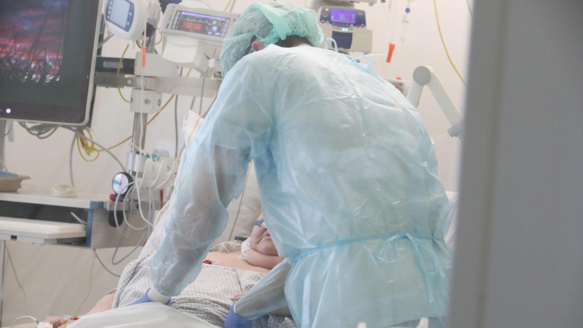 Ein Pfleger überwacht die Monitore bei einem Patienten auf einer Covid 19 Intensivstation. Ein Pfleger überwacht die Monitore bei einem Patienten auf einer Covid 19 Intensivstation.