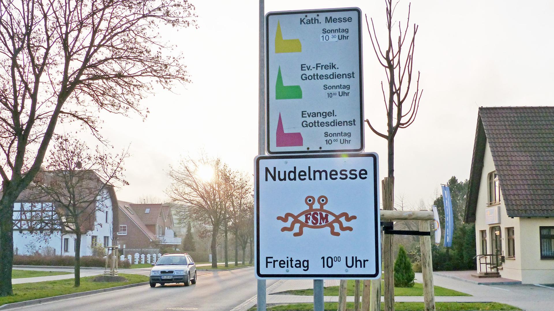 Hinweisschild der "Kirche des Fliegenden Spaghettimonsters" mit den Zeiten der sogenannten Nudelmesse in Templin; aufgenommen im November 2014 Hinweisschild der "Kirche des Fliegenden Spaghettimonsters" mit den Zeiten der sogenannten Nudelmesse in Templin; aufgenommen im November 2014