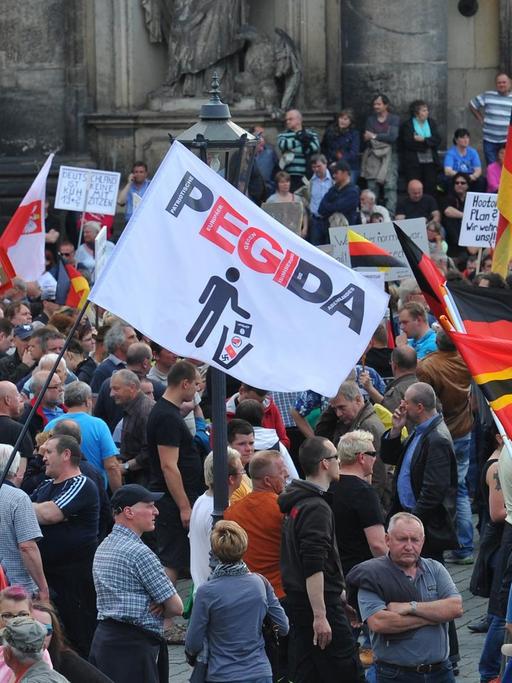 Einige hundert Anhänger des islamkritischen Bündnisses Pegida treffen sich am 04.05.2015 in Dresden (Sachsen) zu einer Kundgebung und halten Deutschland-Fahnen hoch.
