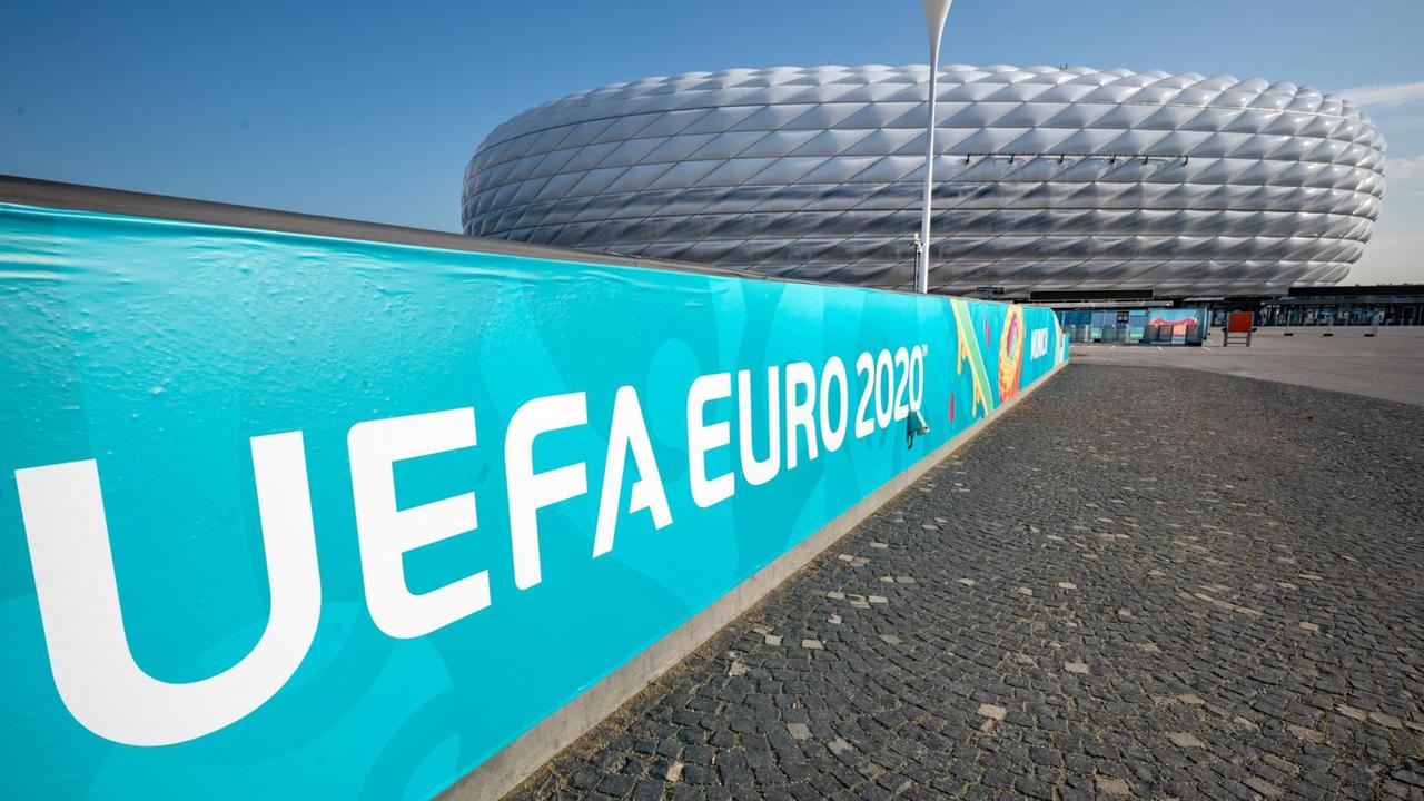 Ein Banner mit der Aufschrift „UEFA Euro 2020“ hängt vor der Allianz Arena in München. 