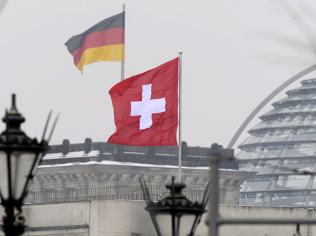 Die Schweizer Flagge weht über der Botschaft in der Nähe zur Glaskuppel des Bundestages.
