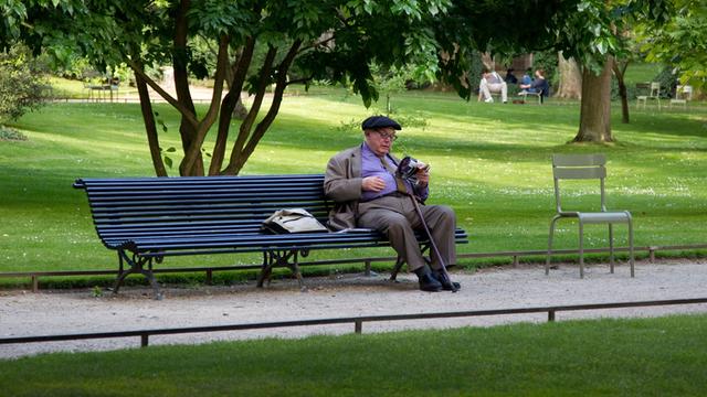 Ein älterer Mann sitzt im Juni 2011 auf einer Bank im Jardin du Luxembourg im französischen Paris und liest.