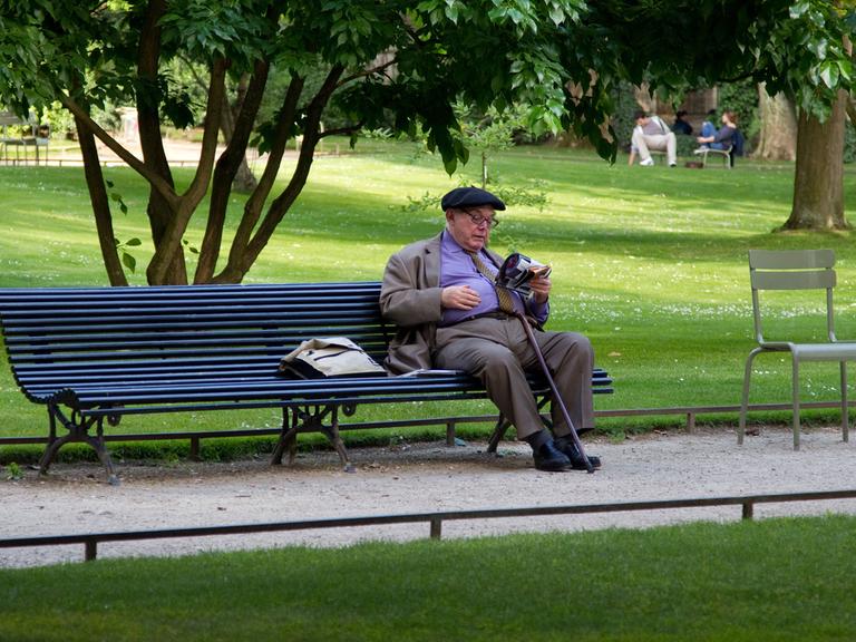 Ein älterer Mann sitzt im Juni 2011 auf einer Bank im Jardin du Luxembourg im französischen Paris und liest.