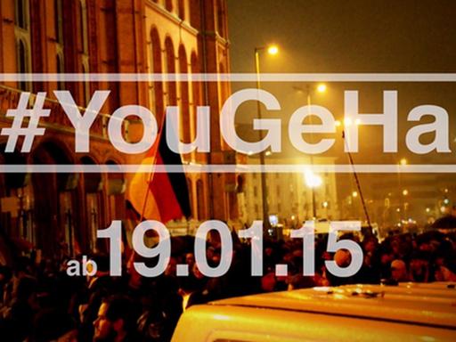 Screenshot des offiziellen #YouGeHa-Trailers. Schrift auf dem Foto von einer Pegida-Demonstration: Youtuber gegen Hass - #YouGeHa - am 19.01.15