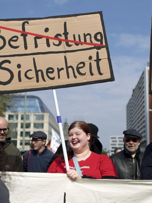 Menschen protestieren am 1. Mai 2017 in Berlin mit Plakaten gegen Leiharbeit und berfristete Arbeitsstellen.