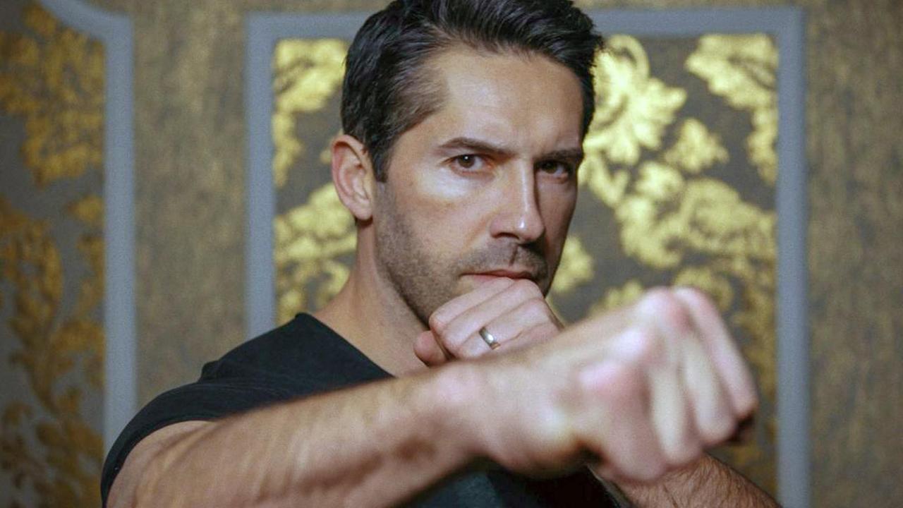 Porträt vom Schauspieler und Kampsportler Scott Adkins in einer Kampfpose, mit zu Fäusten geballten Händen.