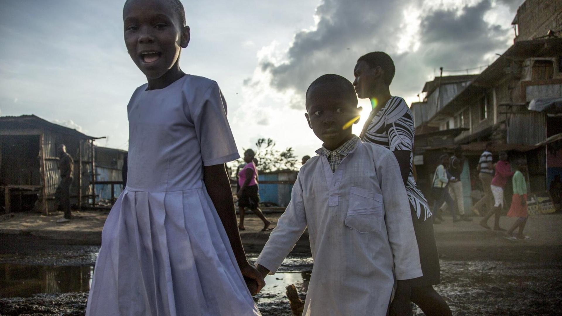 Kinder laufen über eine aufgeweichte Straße im Slum von Mathare in Nairobi /Kenia Kinder laufen über eine aufgeweichte Straße im Slum von Mathare in Nairobi /Kenia