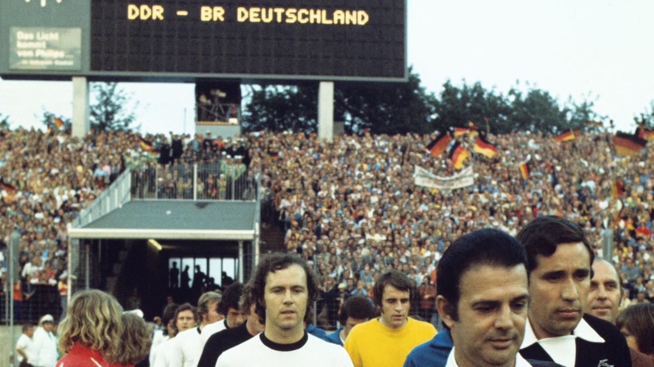 Der Kapitän der deutschen Fußball-Nationalmannschaft, Franz Beckenbauer, beim Einzug in des Volksparkstadion in Hamburg am 22.06.1974. Die bundesdeutsche Elf verlor in der Vorrunde der Fußball-Weltmeisterschaft das Spiel gegen die DDR überraschend mit 0:1 Toren. Torschütze war Jürgen Sparwasser. Ganz rechts der Schiedsrichter Ramon Bareto Ruiz (Uruguay). Der Kapitän der deutschen Fußball-Nationalmannschaft, Franz Beckenbauer, beim Einzug in des Volksparkstadion in Hamburg am 22.06.1974. Die bundesdeutsche Elf verlor in der Vorrunde der Fußball-Weltmeisterschaft das Spiel gegen die DDR überraschend mit 0:1 Toren. Torschütze war Jürgen Sparwasser. Ganz rechts der Schiedsrichter Ramon Bareto Ruiz (Uruguay).