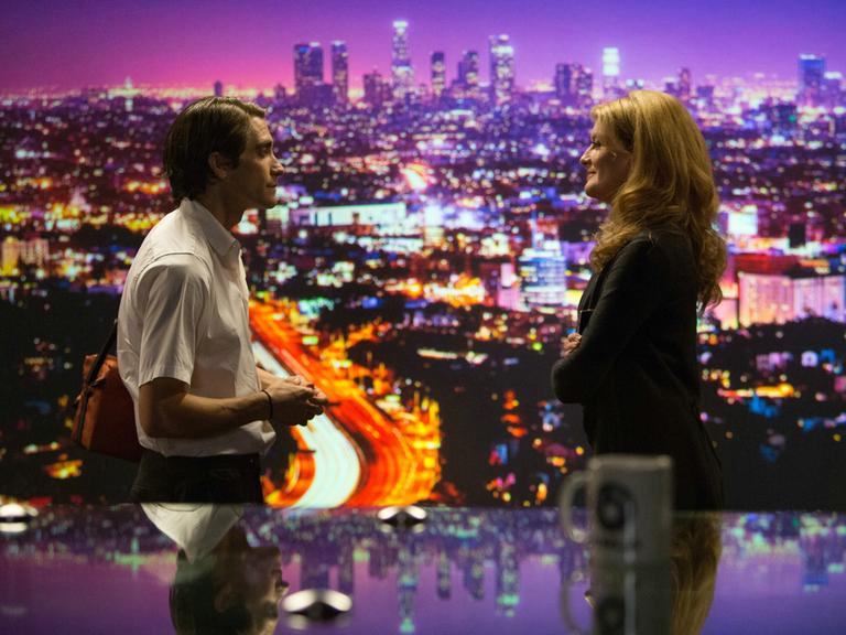Der Kammeramann Lou Bloom (Jake Gyllenhaal) und die Chefredakteurin Nina (Rene Russo) in einer Szene des Films "Nightcrawler - Jede Nacht hat ihren Preis".