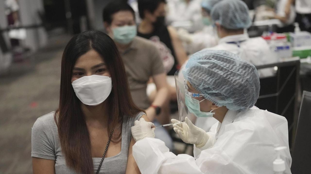 Eine junge Frau erhält in einem Einkaufszentrum in Bangkok eine Impfung gegen das Coronavirus. Eine junge Frau erhält in einem Einkaufszentrum in Bangkok eine Impfung gegen das Coronavirus.