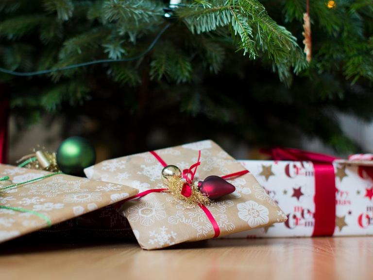 Geschenke liegen unter einem Weihnachtsbaum.