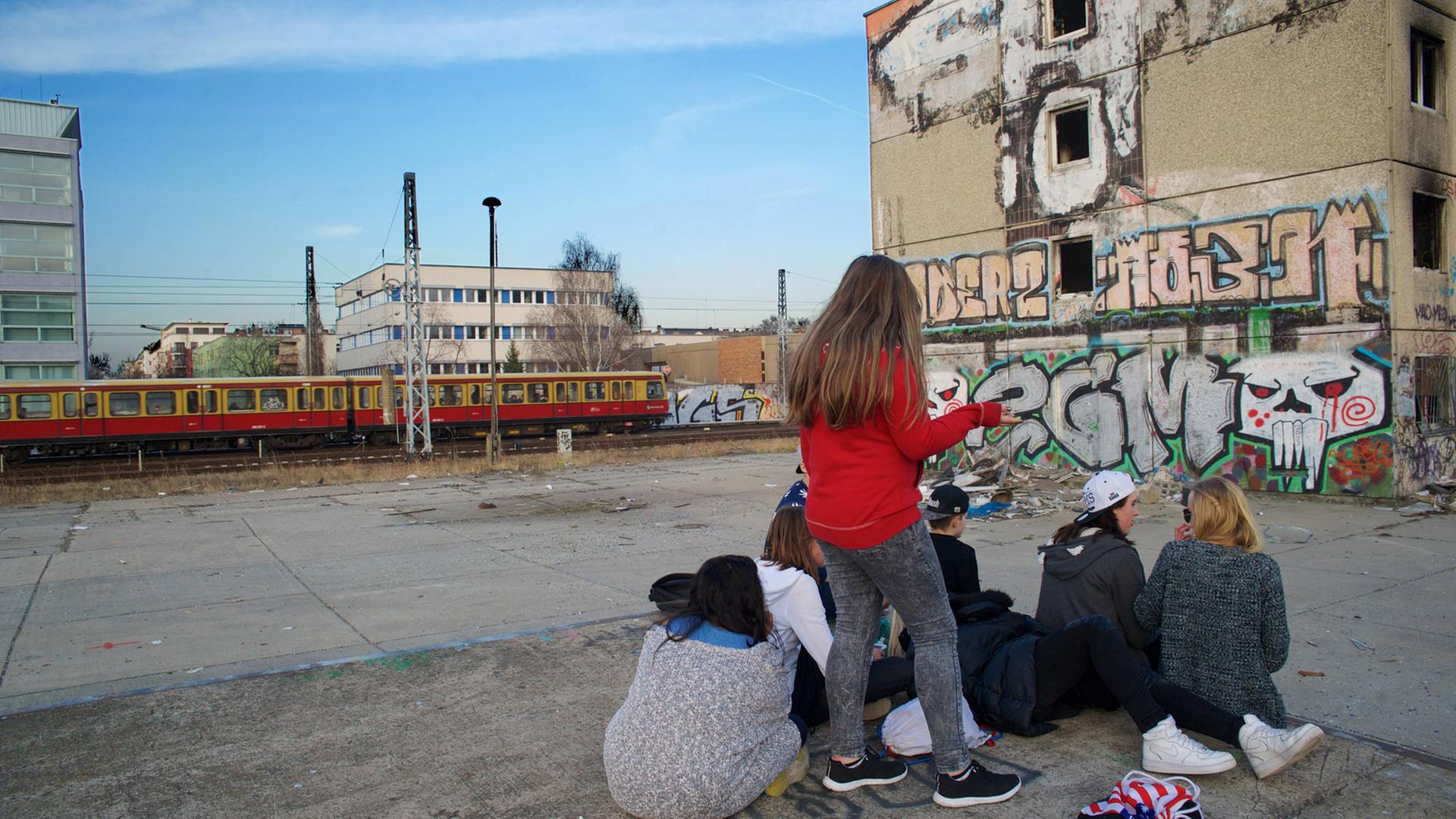Jugendliche auf einer Brache vor einer Ruine (Plattenbau) in Berlin Jugendliche auf einer Brache vor einer Ruine (Plattenbau) in Berlin