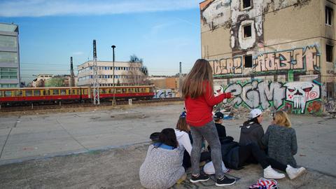 Jugendliche auf einer Brache vor einer Ruine (Plattenbau) in Berlin