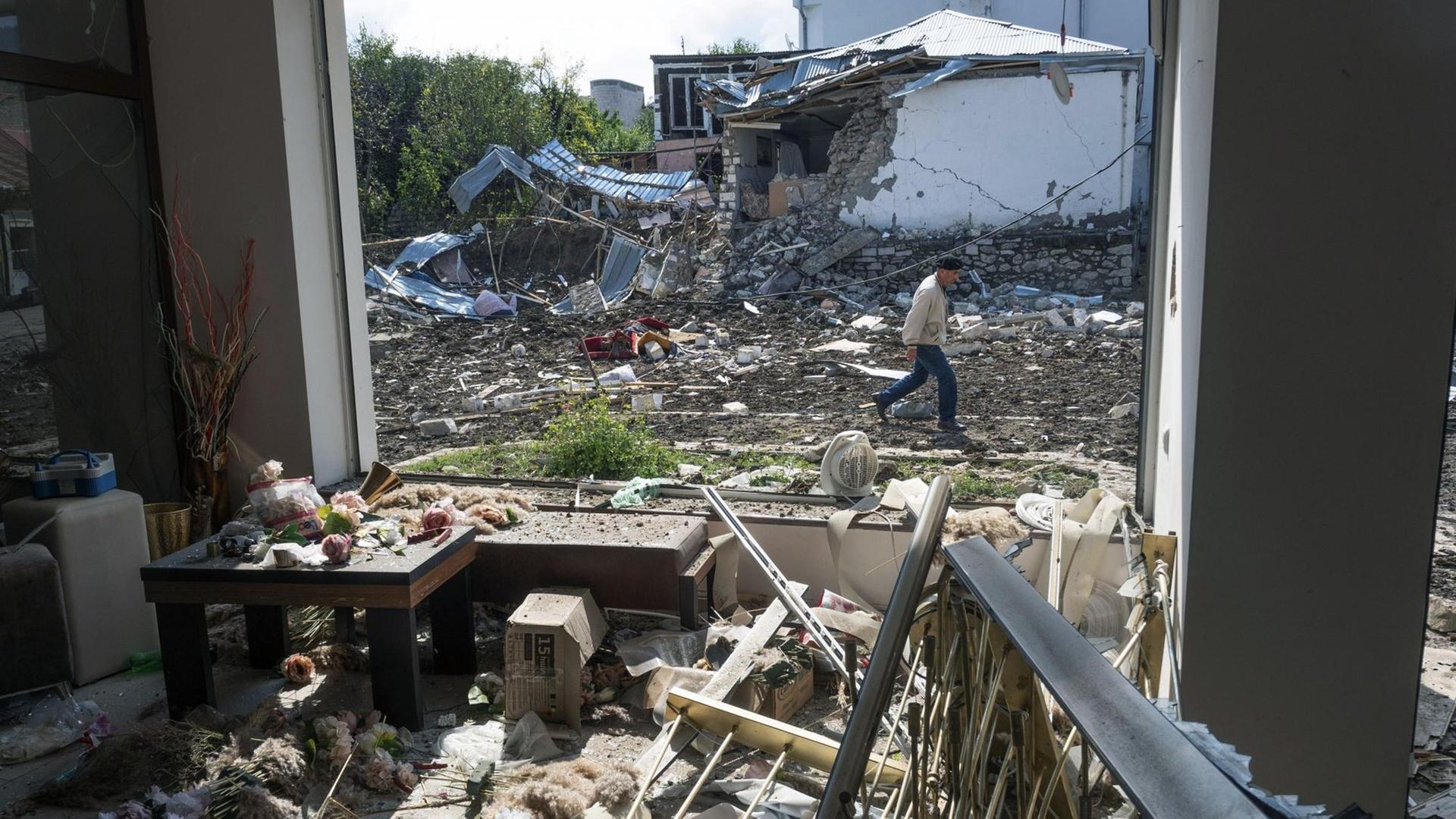 Aserbaidschan, Stepanakert: Ein Mann geht an einem Haus vorbei, das von der aserbaidschanischen Artillerie durch Beschuss zerstört wurde. Aserbaidschan, Stepanakert: Ein Mann geht an einem Haus vorbei, das von der aserbaidschanischen Artillerie durch Beschuss zerstört wurde.