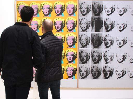 Besucher schauen sich in der US-Retrospektive zum Werk des Künstlers im New Yorker Whitney Museum Andy Warhols Kunstwerk "Marilyn Diptych" an.