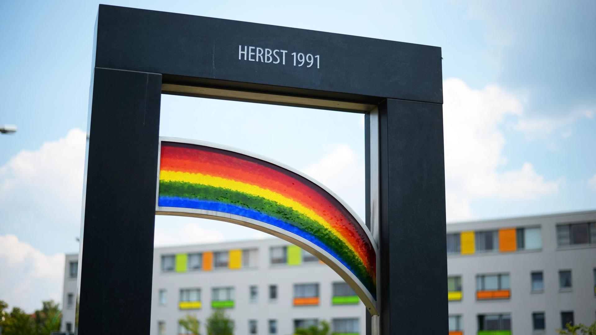 Gedenkstele in Hoyerswerda zeigt einen Regenbogen und die Aufschrift "Herbst 1991"