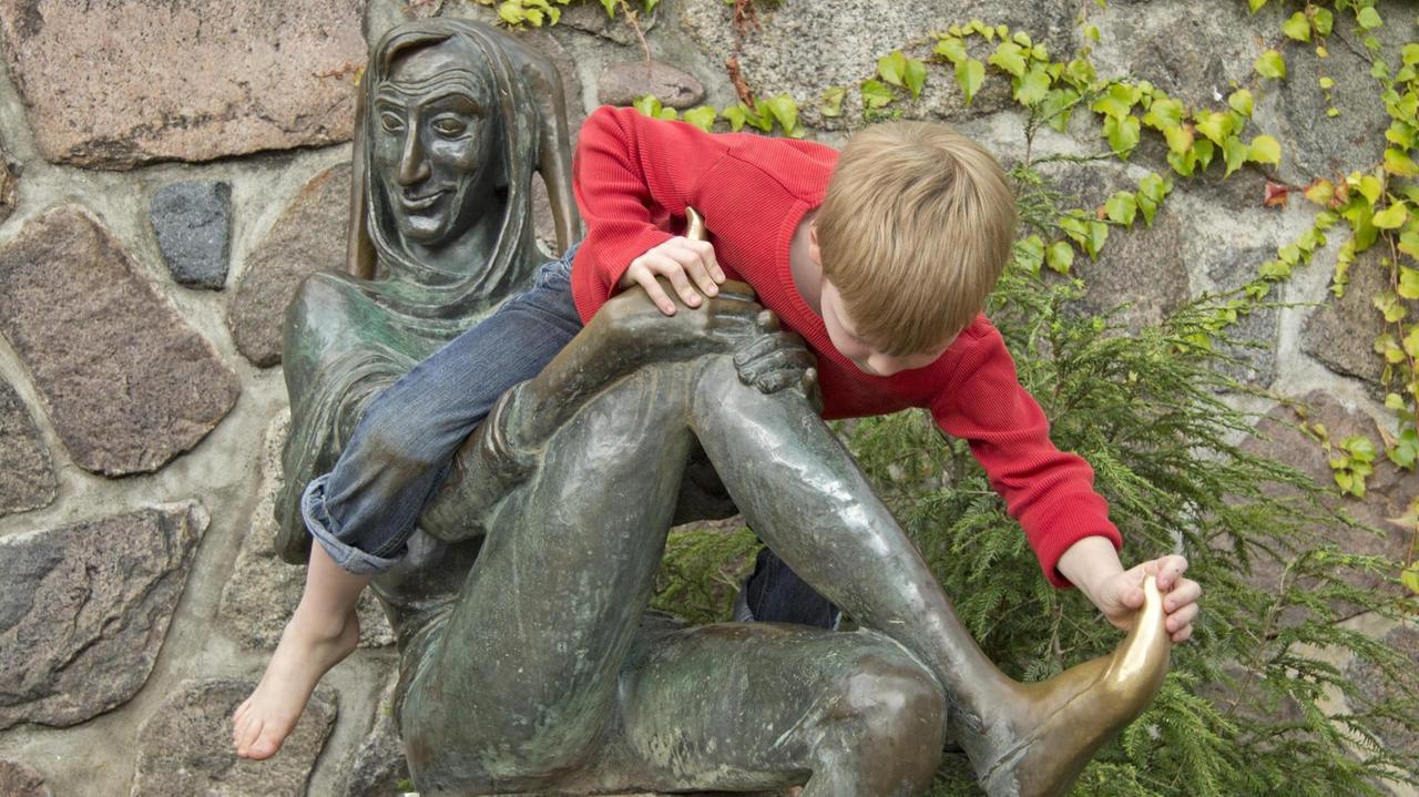 Kleiner Junge auf Eulenspiegel-Statue in Mölln